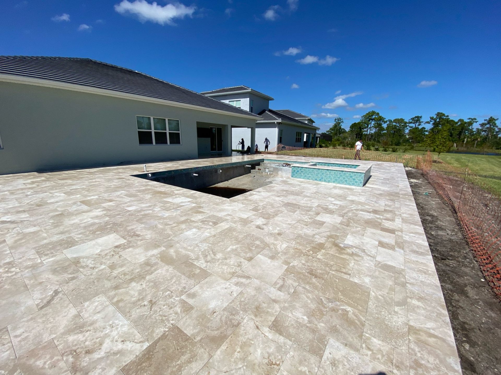 Travertine pool deck installation at a South Florida estate by DMH Associates